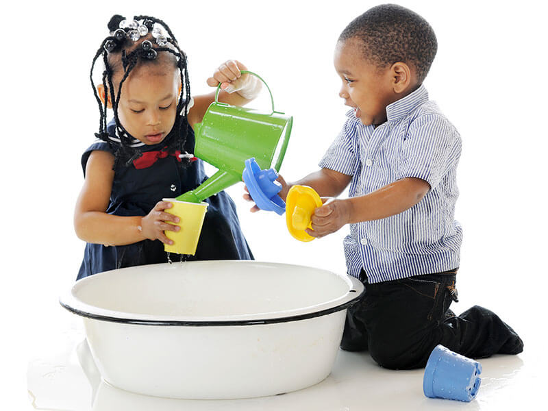 Two youn children playing with water