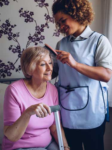 Carer brushing patients hair