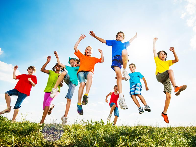Children outdoors jumping up